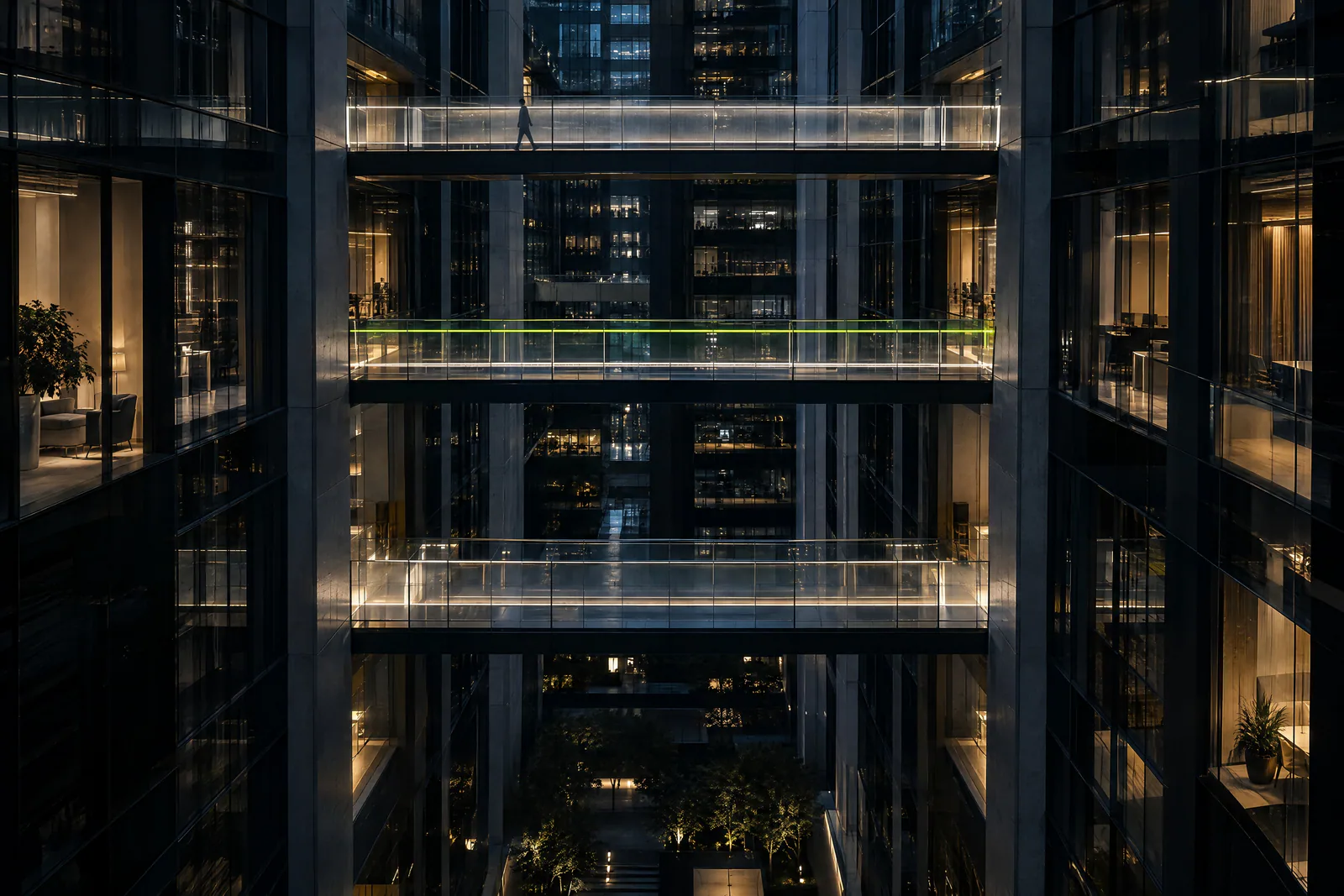 Glass skybridges between office towers at night, lit from within.